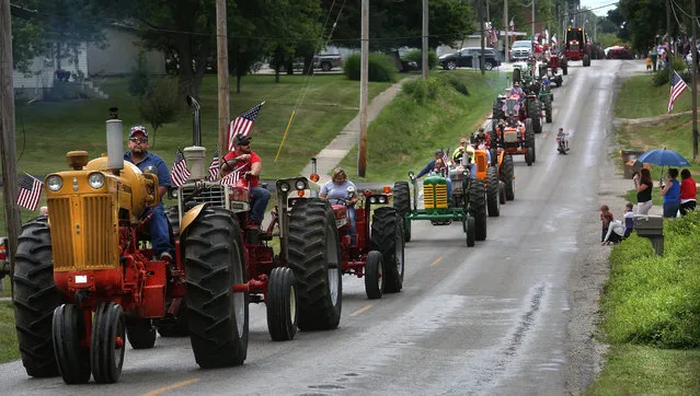 A convoy of antique farm tractors make their way down S. Main Street during the parade Saturday, July 2, 2016 in Loami, Ill. The village of Loami held their annual parade as part of the day-long Fourth of July Celebration at Colburn Park. A car show, music, tractor games, a dunk tank, flea market and other activities was scheduled to be capped off with a fireworks show. (Photo by David Spencer/The State Journal-Register via AP Photo)