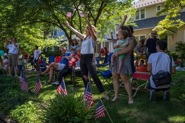 Spectators cheer as floats, cars and participants on foot march through a neighborhood during the 2022 4th of July Parade in Takoma Park, MD on July 04, 2022. (Photo by Craig Hudson for The Washington Post)