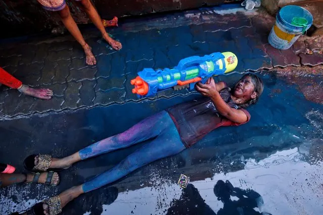 A girl reacts as she plays with a water gun during Holi celebrations in Chennai, India, March 10, 2020. (Photo by P. Ravikumar/Reuters)