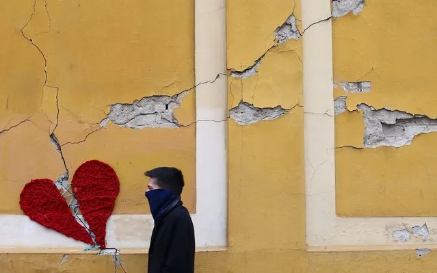 A man walks next to a repaired broken heart made of wool by Croatian designer Ivona, put on a building in downtown Zagreb, Croatia, March 25, 2020, as the country is fighting coronavirus disease (COVID-19) outbreak and the aftermatch of an earthquake that hit the country on March 22. (Photo by Antonio Bronic/Reuters)