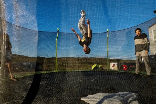 A group of friends play on a trampoline ahead of the visit by Pope Francis to Iqaluit, Nunavut, Canada on July 26, 2022. (Photo by Carlos Osorio/Reuters)