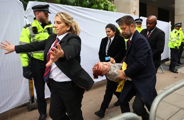 Police officers and security staff remove a demonstrator from the venue of the Energy Intelligence Forum, as Oily Money Out protests take place outside, in London, Britain on October 18, 2023. (Photo by Toby Melville/Reuters)