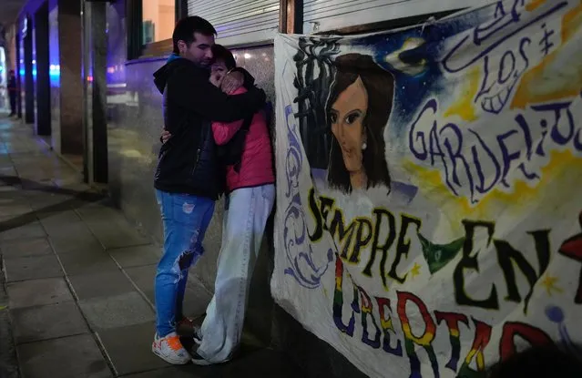 A couple who witnessed when a man pointed a gun at Argentina's Vice President Cristina Fernandez during an event in front of her home in the Recoleta neighborhood of Buenos Aires, Argentina, comfort each other, Thursday, September 1, 2022. (Photo by Natacha Pisarenko/AP Photo)
