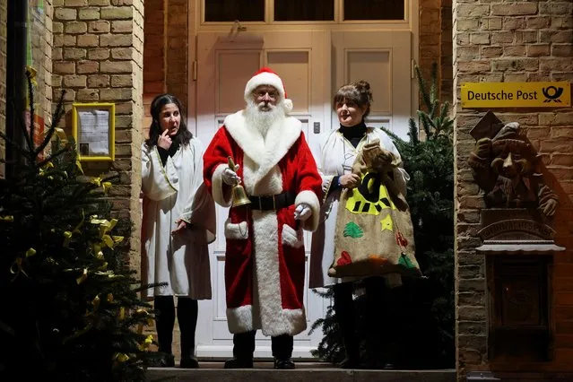 A man dressed as Santa Claus stands in front of the Christmas Deutsche Post office in the village of Himmelpfort (which translates to Heaven's Gate), north of Berlin, Himmelpfort, Germany on December 15, 2021. (Photo by Christian Mang/Reuters)