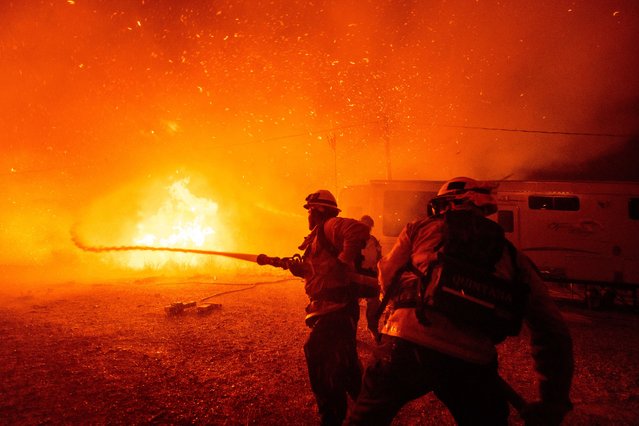 Firefighters spray water on the Hughes Fire in Castaic, Calif., Wednesday, January 22, 2025. (Photo by Ethan Swope/AP Photo)