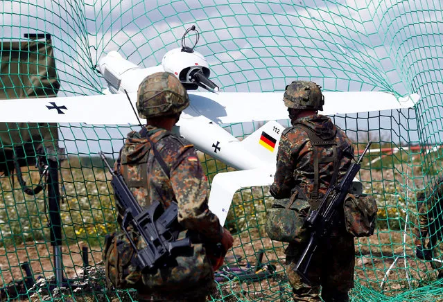 German soldiers remove a Luna drone from a net after its landing at the 13th reconnaissance battalion in Gotha, Germany, August 9, 2016. (Photo by Ralph Orlowski/Reuters)