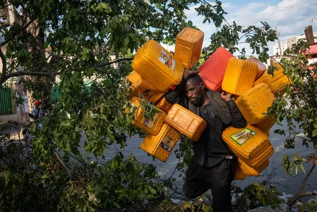 A man carries several buckets to stock up on fuel during the strike against the increase in fuel prices, in Port-au-Prince, Haiti, 28 September 2022. The three-day strike called in Haiti by the public transport unions against the increase in fuel prices once again paralyzed Port-au-Prince and other cities, which have become the scene of massive demonstrations. Not only has transportation been paralyzed in Haiti since last Monday, but also the rest of the activities, with public institutions and private companies closed, which has turned Port-au-Prince into a static city. (Photo by Johnson Sabin/EPA/EFE)