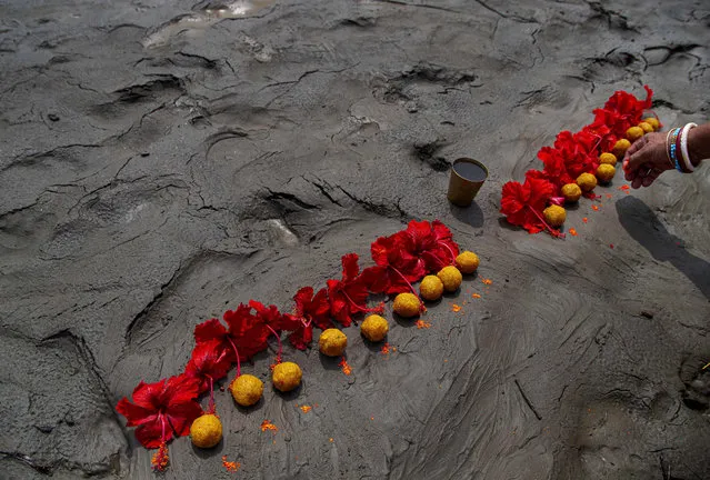 A Hindu woman performs rituals during a prayer ceremony to rid the world of coronavirus, on the banks of the river Brahmaputra in Gauhati, India, Friday, June 5, 2020. (Photo by Anupam Nath/AP Photo)