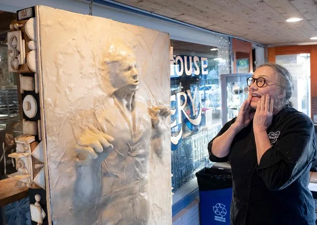 Creator Catherine Pervan describes how she and her daughter made “Pan Solo”, a 6-foot-tall replica of Han Solo frozen in carbonite, made entirely of bread at One House Bakery in Benicia, California, on October 16, 2022. Daughter and mother team Hannalee and Catherine Pervan spent more than 100 hours manually creating the life-sized dough replica of Star Wars' frozen Han Solo as part of a citywide store front scarecrow competition. (Photo by Josh Edelson/AFP Photo)