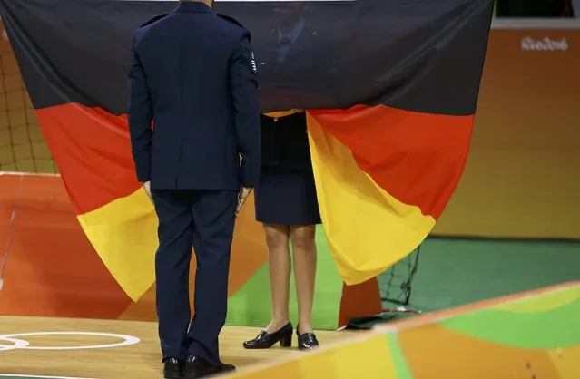2016 Rio Olympics, Handball, Victory Ceremony, Men's Victory Ceremony, Future Arena, Rio de Janeiro, Brazil on August 21, 2016. Officials prepare to raise the German flag during the victory ceremony. (Photo by Damir Sagolj/Reuters)