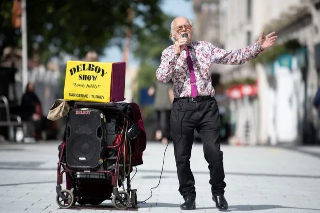 A busker performs the “Del Boy show” for shoppers on Queen Street as non-essential shops open for the first time since the start of lockdown on June 22, 2020 in Cardiff, United Kingdom. The First Minister of Wales Mark Drakeford has announced that all non-essential shops will be allowed to open their doors again in Wales from today but people will be asked to continue to “stay local” with five miles given as guidance until July 6. (Photo by Matthew Horwood/Getty Images)
