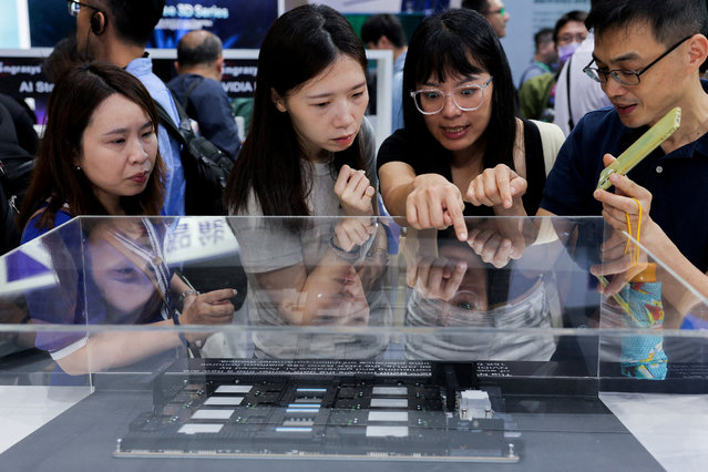 A group of people study equipment on display at Computex in Taipei, Taiwan on June 5, 2024. (Photo by Ann Wang/Reuters)