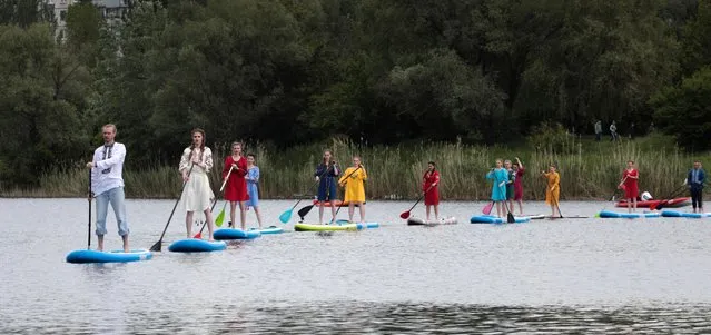 Models wearing Vyshyvankas present creations by Ukrainian brand ETHNO SYMBOL on stand up paddle boards during a fashion show on water in Kharkiv, Ukraine, 23 May 2020. Vyshyvanka is a Slavic traditional attire that contains elements of Ukrainian ethnic embroidery. The Ukrainian government started easing restrictions implemented to stem the spread of the SARS-CoV-2 coronavirus that causes the COVID-19 disease. A so-called adaptive quarantine will be in effect in the country from 23 May 2020 on. (Photo by Sergey Kozlov/EPA/EFE/Rex Features/Shutterstock)