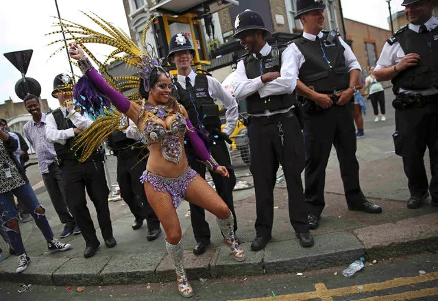 Police look as a performer dances during the Notting Hill Carnival in London, Britain August 29, 2016. (Photo by Neil Hall/Reuters)