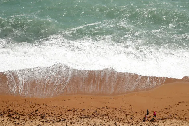 People take a walk on the beach near Durdle Door, following the outbreak of the coronavirus disease (COVID-19), Lulworth, Britain, May 23, 2020. (Photo by Matthew Childs/Reuters)