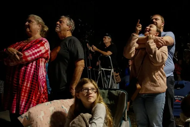 People at Veterans Memorial park watch as the Artemis I unmanned lunar rocket lifts off from launch pad 39B at NASA's Kennedy Space Center, in Titusville, Florida, on November 16, 2022. (Photo by Marco Bello/AFP Photo)