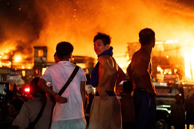 Residents watch a fire in a residential area in Manila, Philippines, on April 23, 2025. (Photo by Lisa Marie David/Reuters)