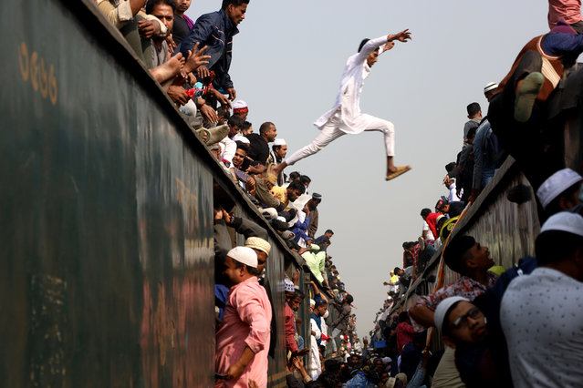 A devotee of Bishwa Ijtema jumps from one train to another to reach the right train at Tongi railway station in Gazipur, Bangladesh on February 4, 2024. Bishwa Ijtema (world Ijtema) is the second largest muslim gathering in the world. Millions of people from all over the country and abroad participate in Ijtema every year. (Photo by Syed Mahabubul Kader/ZUMA Press Wire/Rex Features/Shutterstock)
