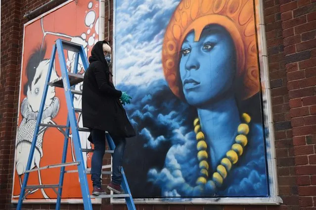 Norwegian street artist “Zina” creates an artwork as she takes part in the “Sand Sea & Spray” Urban Art Festival in Blackpool, north west England on July 11, 2015. (Photo by Oli Scarff/AFP Photo)