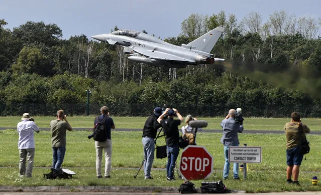 Journalists watch the take off of a German Eurofighter jet at the airbase in Noervenich, Germany, Thursday, August 20, 2020. (Photo by Martin Meissner/AP Photo)