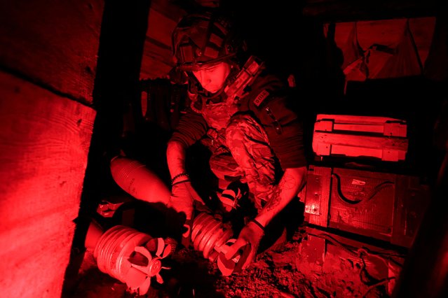 A service member of the 115th Separate Mechanized Brigade of the Ukrainian Armed Forces prepares mortar shells before they are fired at Russian troops, at a position in a front line, amid Russia's attack on Ukraine, in Donetsk region, Ukraine on May 16, 2025. (Photo by Sofiia Gatilova/Reuters)