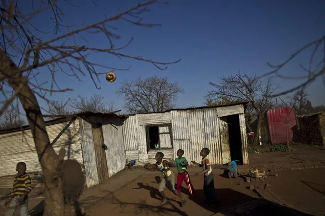 South African children play football with a torn ball in a yard in a Soweto township on the outskirts of Johannesburg, South Africa, Wednesday, July 3, 2013. (Photo by Muhammed Muheisen/AP Photo)
