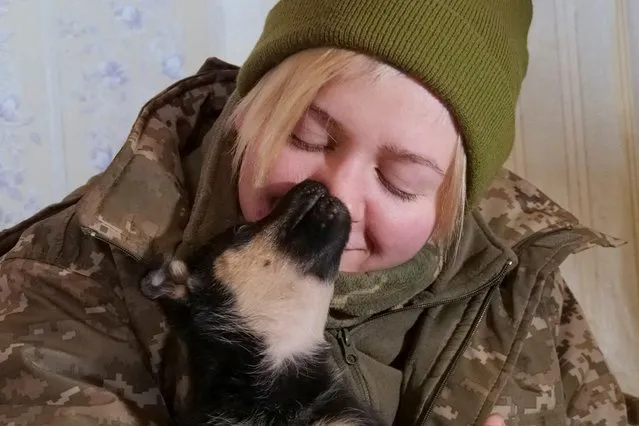 Ukrainian servicewoman Valeriia, 28, holds one of two puppies found two weeks ago in an abandoned house in a frontline, amid Russia's attack on Ukraine, near the town of Bakhmut, Donetsk region, Ukraine on December 5, 2022. (Photo by Vladyslav Smilianets/Reuters)