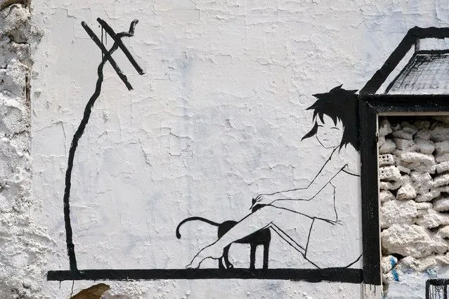 “A girl and her cat”. Athens street art, Greece. (Photo by Michel)