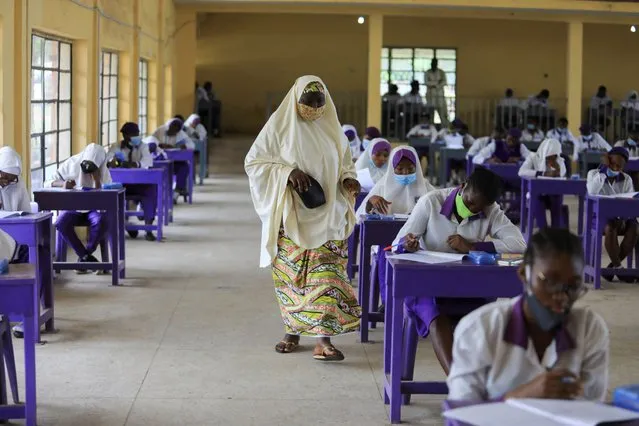 An exam inspector is seen walking across the hall as Students of Government Secondary School Wuse, are seen taking the West African Examination Council (WAEC) 2020 test, after the coronavirus disease (COVID-19) lockdown in Abuja, Nigeria on August 17, 2020. (Photo by Afolabi Sotunde/Reuters)