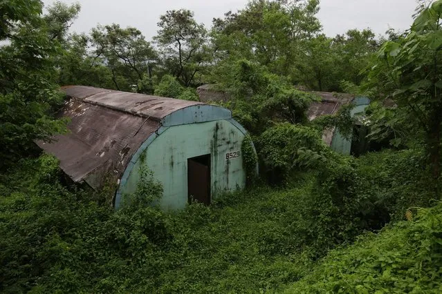 In this October 18, 2014, photo, a row of concrete structures called “Quonset huts” lie inside the Subic Bay Freeport Zone, Zambales province, northern Philippines. The huts were used as barracks for U.S. Marines inside the former American naval base. It was closed in 1992 after the Philippine Senate voted not to extend the lease on the facility. Some of the abandoned huts were reused as dormitories and staff houses for employees. Other abandoned huts have not been touched since U.S. forces left 22 years ago. (Photo by Aaron Favila/AP Photo)