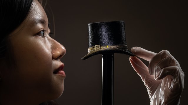 Kelly Tang on Wednesday, March 13, 2024 views a tiny top hat from a collection of vintage miniature millinery, made by Leeds hatter John Craig in the early 1900s, which are being documented and conserved by museum experts and volunteers at the Leeds Discovery Centre, UK. (Photo by Danny Lawson/PA Images via Getty Images)