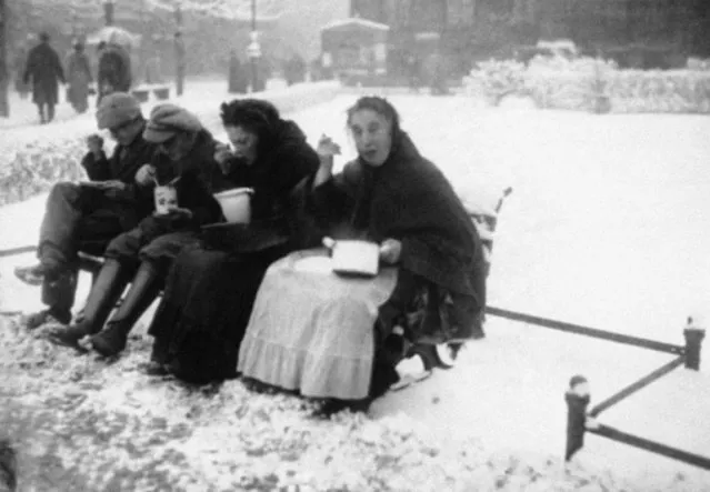 Sharing one of a warm meal from one of the municipal kitchens of Berlin on December 14, 1923, where the heat of the food is a pleasant treat for the poor populace who take the advantage of warmth to guard against the chilly weather. (Photo by AP Photo)