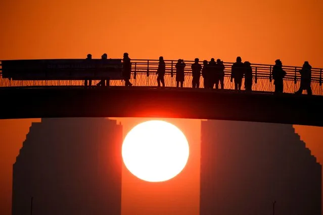 People look at the first sunrise of the year at a park in Seoul, South Korea on January 1, 2023. (Photo by Kim Hong-Ji/Reuters)
