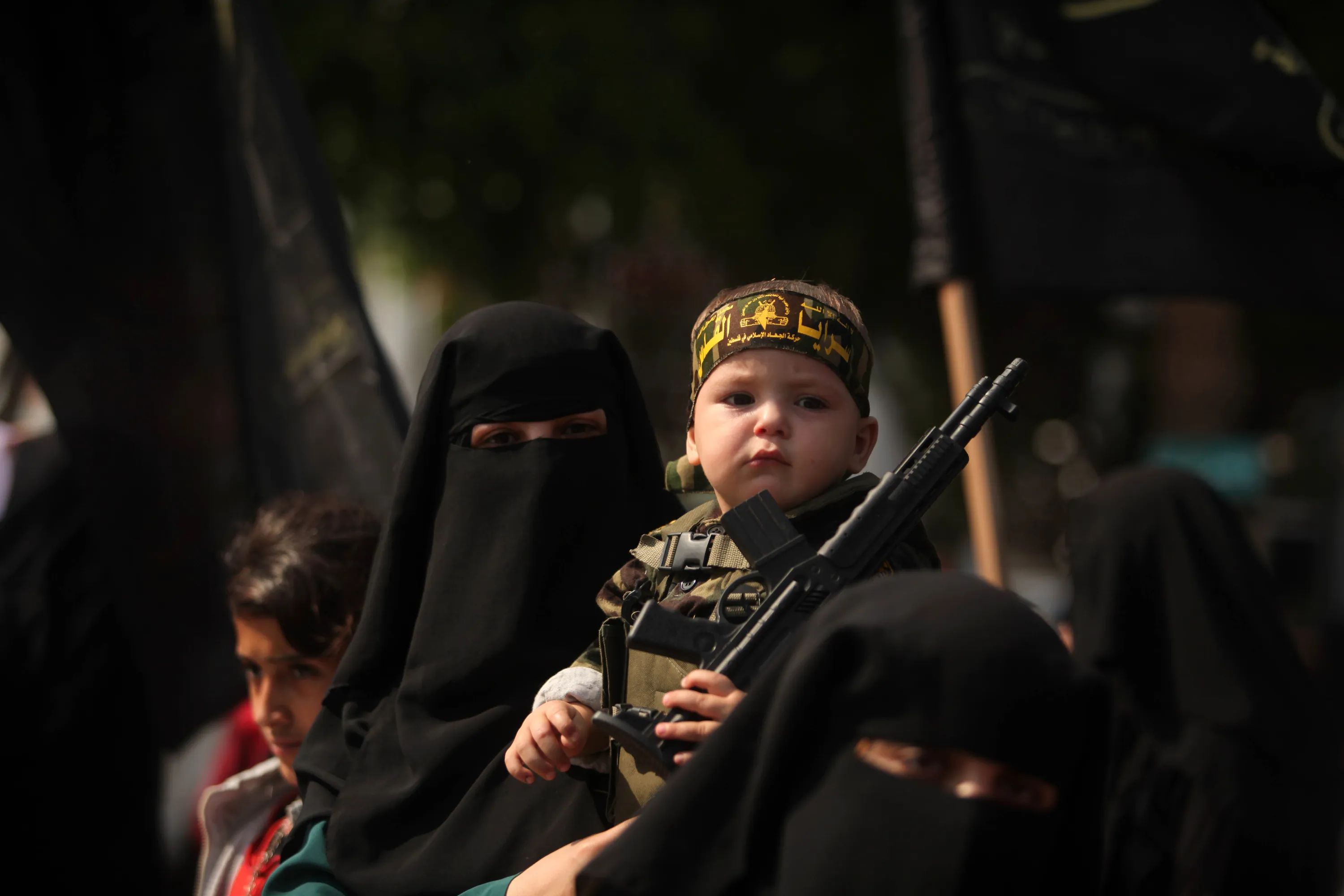A Palestinian woman supporting the Islamic jihad movement holds her son dur...