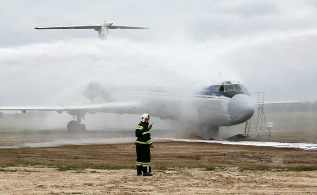 Ukrainian emergency workers spray a plane with water hoses as part of a rescue training exercise at Boryspil International Airport outside Kiev, Ukraine, September 27, 2016. (Photo by Valentyn Ogirenko/Reuters)