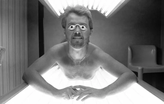 Brent Atteberry evens his tan at a suntan salon in Chicago on Friday, January 27, 1984 while most city dwellers were bundling up against the winter cold dreaming of some sunny beachfront. The goggles are worn to protect eyes from tanning rays. (Photo by Mark Elias/AP Photo)