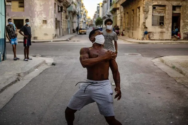 People wearing masks as a precaution against the spread of the new coronavirus play handball on a street in Havana, Cuba, Monday, August 31, 2020. Cuban authorities will introduce new measures starting tomorrow Tuesday aimed at containing the spread of the coronavirus in Havana among others a curfew from 7 pm until 5 am and no one without special permission will be able to enter or leave the province. The new measures will last at least 15 days. (Photo by Ramon Espinosa/AP Photo)