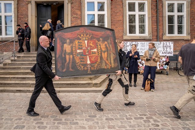 People carry a historic painting out of the Old Stock Exchange, Boersen, during a fire in the historic building, in Copenhagen, Denmark on April 16, 2024. (Photo by Ida Marie Odgaard/Ritzau Scanpix)