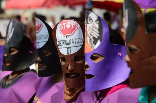A Bangladeshi woman wearing masks take part in a rally to mark International Women's Day in Dhaka on March 8, 2018. Thousands of Bangladeshi women, non-governmental organisations and rights groups activists took to the streets demanding safer lives for women in the country as well as an improvement in their social conditions. (Photo by Munir Uz Zaman/AFP Photo)