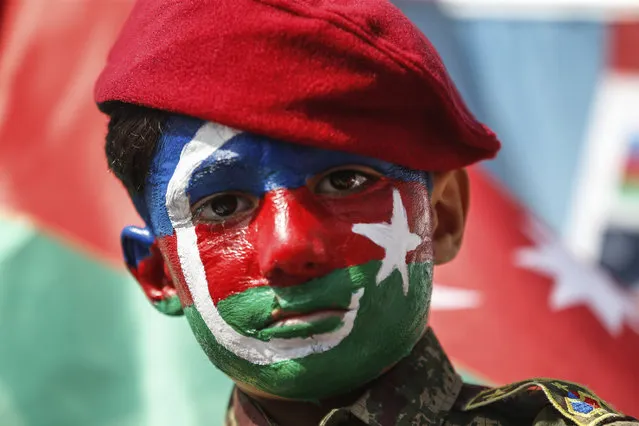 A child, his face covered with the colours of the flag of Azerbaijan participates in a protest supporting Azerbaijan, in Istanbul, Sunday, October 4, 2020. Armenian and Azerbaijani forces continue their fighting over the separatist region of Nagorno-Karabakh, following the reigniting of a decades-old conflict. Turkey, which strongly backs Azerbaijan, has condemned an attack on Azerbaijan's second largest city Gence and said the attack was proof of Armenia's disregard for law. (Photo by Emrah Gurel/AP Photo)