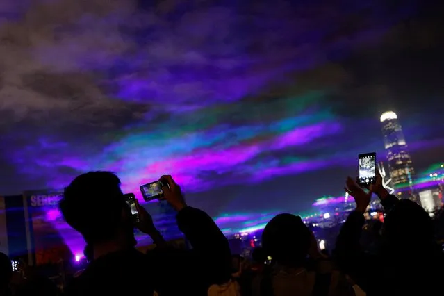 People take photos of the northern lights installation “Borealis” by Dan Acher in Hong Kong, China on February 18, 2023. (Photo by Tyrone Siu/Reuters)