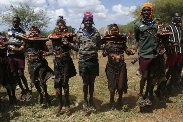 Pokot girls and boys dance together during an initiation ceremony of over a hundred girls passing over into womanhood, about 80 km (50 miles) from the town of Marigat in Baringo County December 6, 2014. (Photo by Siegfried Modola/Reuters)