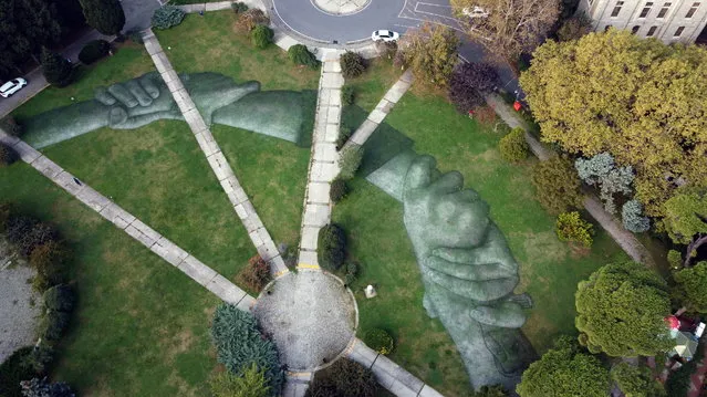 An aerial view shows an artwork by French-Swiss street artist Saype called “Beyond Walls” at Bogazici University in Istanbul, Turkey October 26, 2020. The art pieces created by Saype in Istanbul are the eighth step of a project to create a spray-painted “human chain” across the world to encourage humanity and equality. Picture taken with a drone. (Photo by Murad Sezer/Reuters)