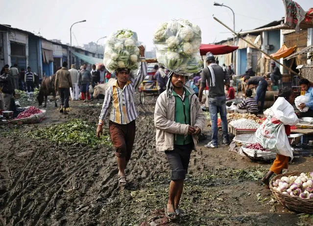 Vendors carry cauliflower for sale at a vegetable wholesale market in New Delhi December 15, 2014. India's wholesale price inflation eased for a sixth straight month in November to its lowest in nearly 5-1/2 years, mainly driven by a sharp fall in fuel prices, government data showed on Monday. (Photo by Anindito Mukherjee/Reuters)