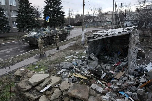 Ukrainian servicemen stand near a building damaged during fighting between pro-Russian rebels and Ukrainian government forces in the eastern Ukrainian town of Debaltseve in Donetsk region, December 24, 2014. (Photo by Valentyn Ogirenko/Reuters)