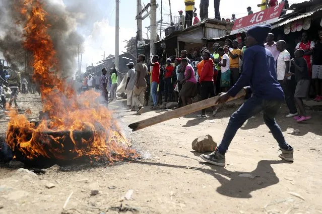 A protestor burns tyres to block the road on the outskirts of Nairobi, Thursday, March 30, 2023. (Photo by Brian Inganga/AP Photo)