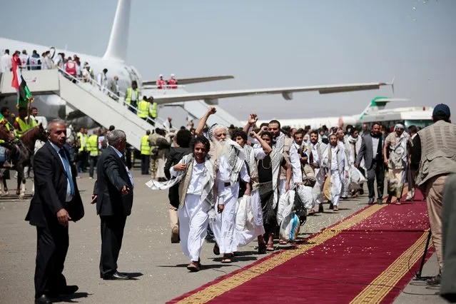 Yemeni prisoners chant slogans during their arrival after being released by the Saudi-led coalition at the airport in Sanaa, Yemen, Friday, October 16, 2020. Yemen's warring sides completed a major, U.N.-brokered prisoner swap on Friday, officials said, a development that could revive the country's stalled peace process after more than five years of grinding conflict. (Photo by Hani Mohammed/AP Photo)