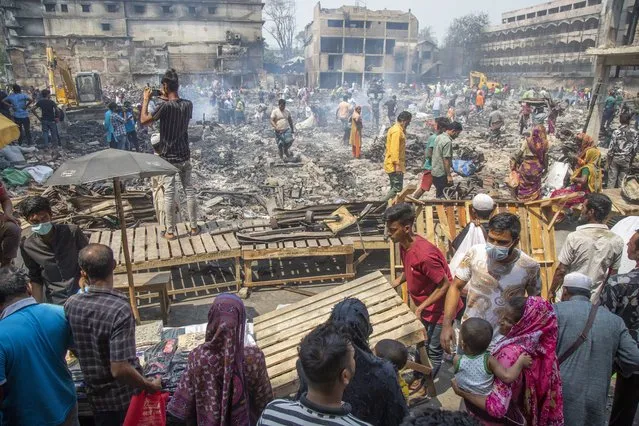 Bangabazar fire-affected traders set up makeshift stalls on a footpath near the gutted area in Dhaka, Bangladesh, 10 April 2023. Vendors who were affected by the fire that broke out at the cloth market of Bangabazar Shopping Complex on 04 April, are resuming their business from makeshift stalls as authorities continue to clear the area. Fire service and Dhaka South City Corporation formed two separate committees to find out the cause of the fire. (Photo by Monirul Alam/EPA)