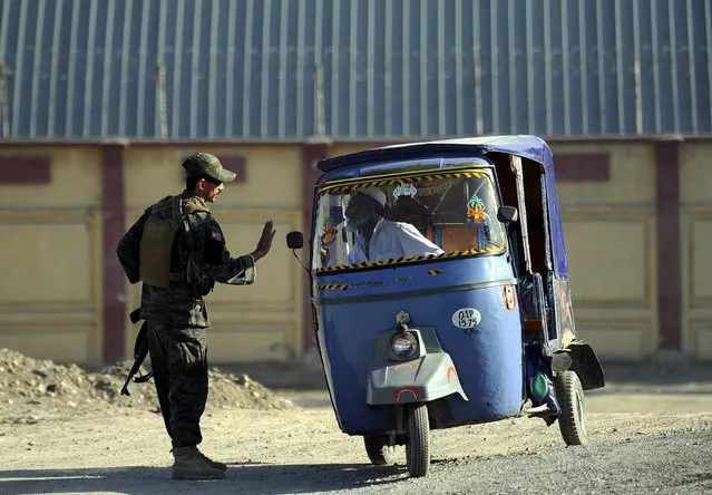 A soldier checks an auto Rickshaw outside the Forward Operating Base or Jalalabad Airport in Jalalabad, Afghanistan, 02 October 2015. A US military C-130 J transport plane crashed in Jalalabad, eastern Afghanistan, killing six crew and five civilian passengers, the US air force said late 01 October. The cause of the incident is still under investigation. (Photo by Ghulamullah Habibi/EPA)