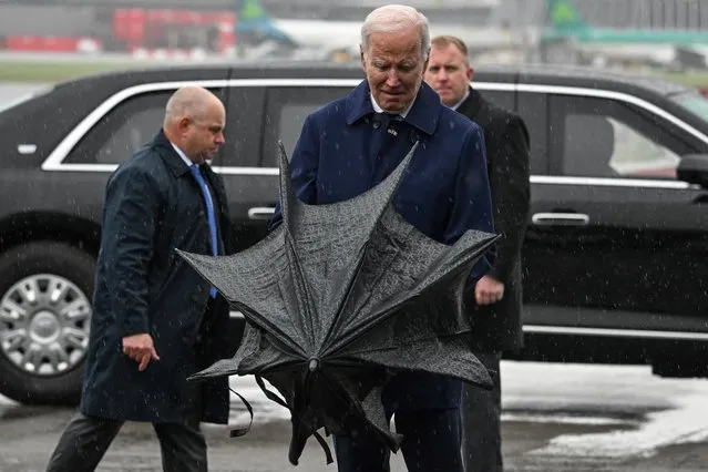 US President Joe Biden opens an umbrella upon arrival at the Dublin International airport, on April 12, 2023, as part of a four day trip to Northern Ireland and Ireland for the 25th anniversary commemorations of the “Good Friday Agreement”. (Photo by Jim Watson/AFP Photo)